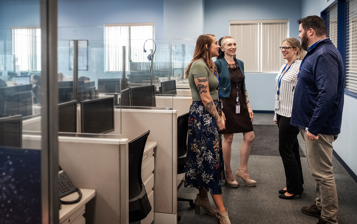Four employees standing and chatting